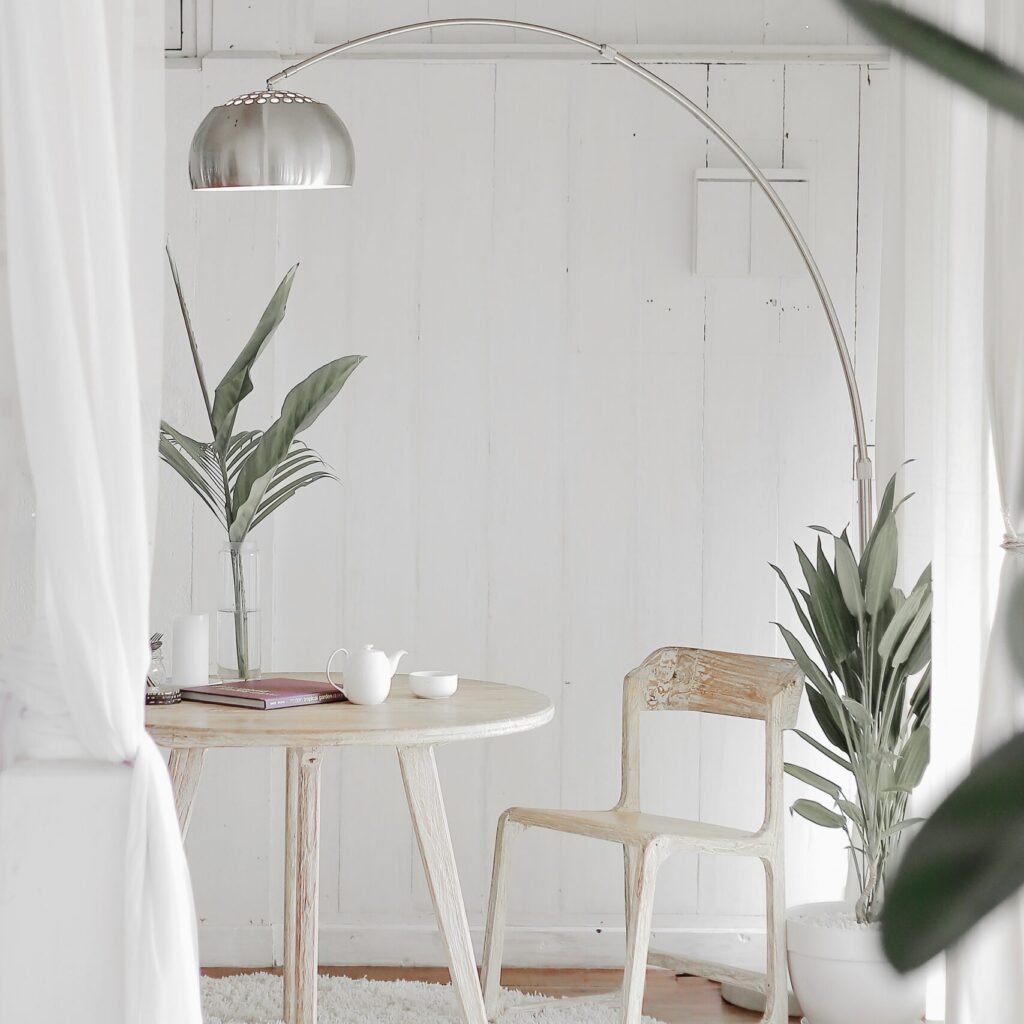 white steel chair in front round table on white rug